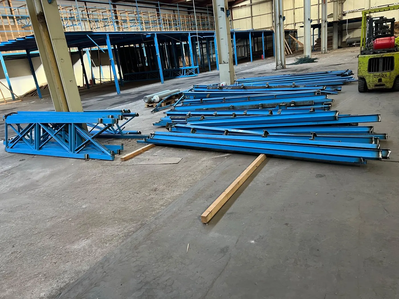 Demontierte blaue Stahlkonstruktion in einer Lagerhalle