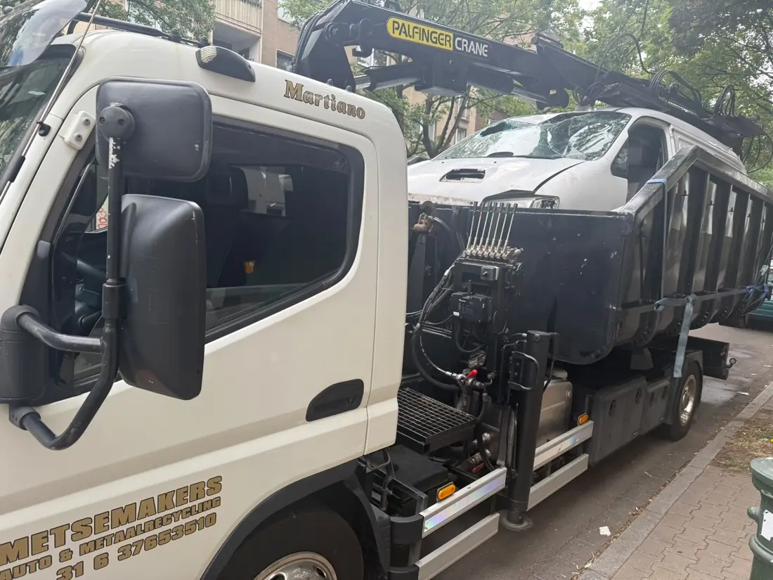 Lkw mit Ladekran beim Verladen eines Altfahrzeugs